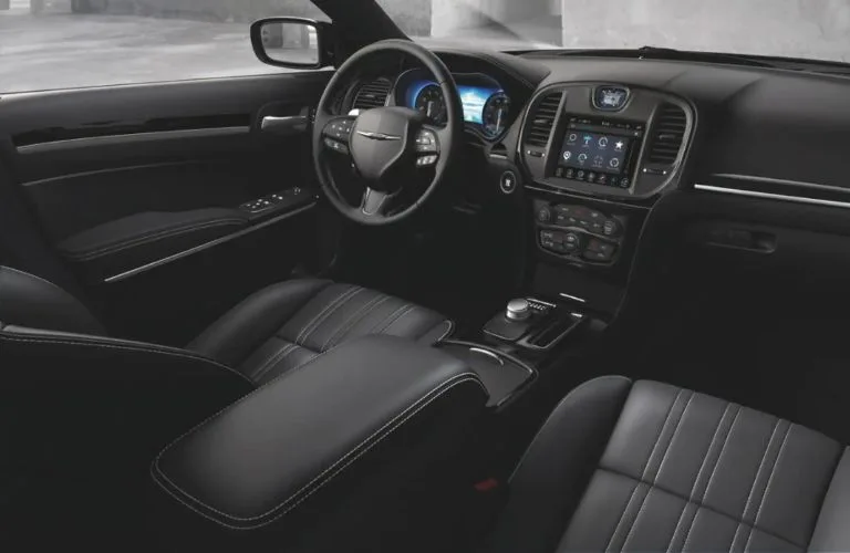 Executive sedan front cabin with leather seating, steering wheel, and centre touchscreen